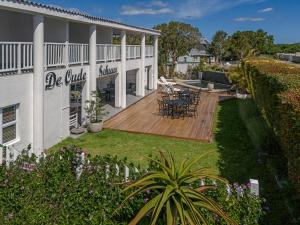 a house with a deck and a patio at Oude Schuur Boutique Guesthouse in Hermanus