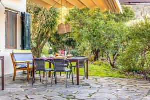 een patio met een tafel, stoelen en bomen bij Antoniana in La Spezia
