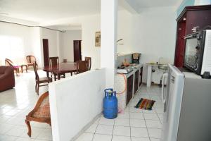 Una cocina y una sala de estar con refrigerador y una mesa. en Athula Hikka beach Guesthouse, en Hikkaduwa 8 fotos más