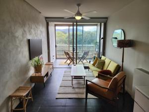 sala de estar con sofá, sillas y TV en Boutique City Apartment with Iconic Mountain Views en Canberra