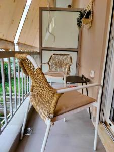 a rattan chair on the balcony of a tiny house at Elpis' cozy & luxury apartment in Athens