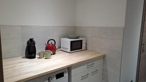 eine Küchentheke mit einer Mikrowelle und einigen Tassen in der Unterkunft Chez Grégory et Nadine in Houssen