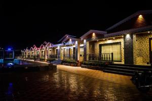 uma fila de casas iluminadas à noite em Grand Beach Resort em Mandarmoni