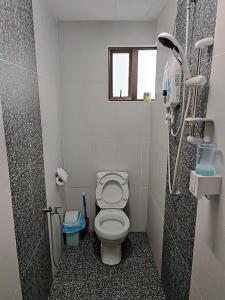 uma pequena casa de banho com um WC e uma janela em Cozy Condo at Melaka Top Hill, 7-9pax em Ayer Keroh