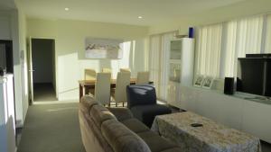 a living room with a couch and a table at GREENWAY WATERS Apartments in Tuggeranong
