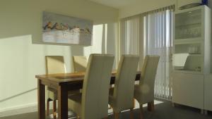 a dining room with a wooden table and chairs at GREENWAY WATERS Apartments in Tuggeranong