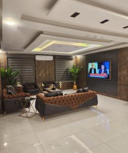 un soggiorno con divano e TV a schermo piatto di رويال جروب اربد Royal Group Hotel a Irbid