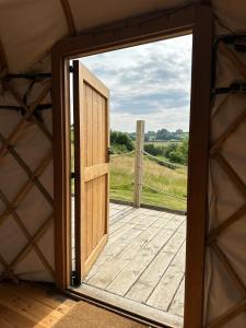 an open door to a porch in a yurt at Bracken Yurt at Walnut Farm Glamping in Netherbury
