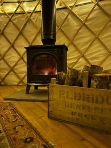 a stove in a yurt with a wooden floor at Bracken Yurt at Walnut Farm Glamping in Netherbury