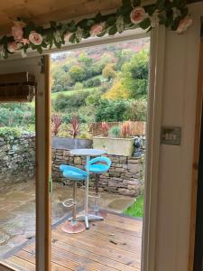 a patio door with a table and two chairs on a deck at 1 Bed converted Railway Wagon near Crickhowell in Crickhowell