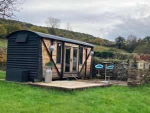 a small shed sitting in the middle of a field at 1 Bed converted Railway Wagon near Crickhowell in Crickhowell