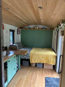 um quarto com uma cama numa pequena casa em 1 Bed converted Railway Wagon near Crickhowell em Crickhowell