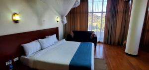 a bedroom with a bed and a large window at Yiganda Hotel - Ethiopia in Bahir Dar