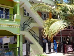 a woman standing on a balcony of a building at Srinilayam in Mysore