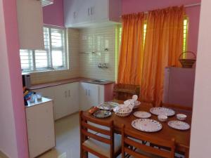 a kitchen with a table with plates and dishes on it at Srinilayam in Mysore