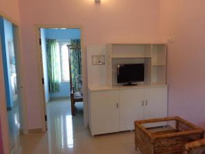 a living room with a flat screen tv in a room at Srinilayam in Mysore