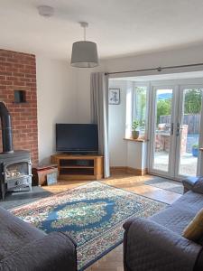 a living room with a tv and a fireplace at 3 Bedroom Bungalow in Llanrhaeadr Ym in Oswestry