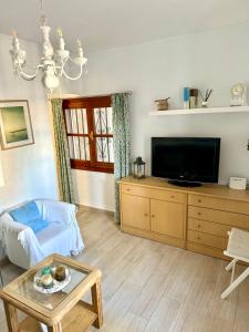 ein Wohnzimmer mit Fernseher und Tisch in der Unterkunft CASA EN PLENO CENTRO DE LA CALA DE MIJAS by Holidays2Rent in La Cala de Mijas