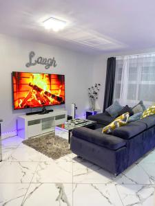 uma sala de estar com um sofá e uma televisão grande em 2 Double Bedroom Apartment in Edgware, London em Edgware