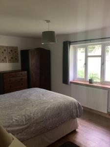 a bedroom with a bed and two windows at 3 Bedroom Bungalow in Llanrhaeadr Ym in Oswestry