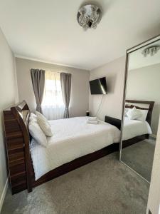1 dormitorio con 1 cama grande y espejo en 2 Double Bedroom Apartment in Edgware, London en Edgware