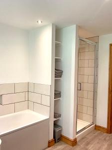 a bathroom with a bath tub and a shower at 3 Bedroom Bungalow in Llanrhaeadr Ym in Oswestry