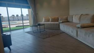 a living room with a couch and a table at شاليه ارض السعاده 1 in Obhor
