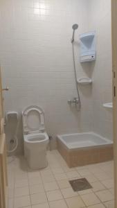 a bathroom with a toilet and a bath tub at شاليه ارض السعاده 1 in Obhor