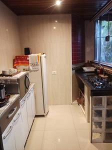 a kitchen with a stove and a refrigerator in it at Hospedagem San Gonzales in Sorocaba