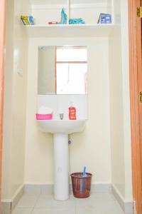 ein Bad mit einem Waschbecken und einem Spiegel in der Unterkunft Home Croft in Eldoret
