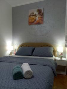 a bedroom with a bed with towels on it at Apartman Central in Bijeljina