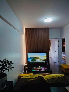 a living room with a couch and a tv on the wall at YourHomeAway,LuxFlat at BristleRidge Baguio in Baguio