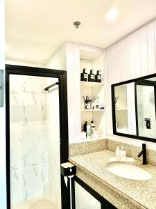 bagno con lavandino e specchio di YourHomeAway,LuxFlat at BristleRidge Baguio a Baguio