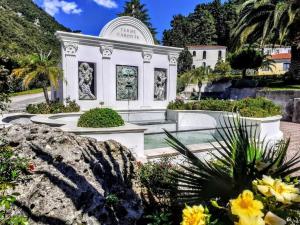 a large white building with statues in a garden at Comodo appartamento in zona centrale e strategica. in Lamezia Terme