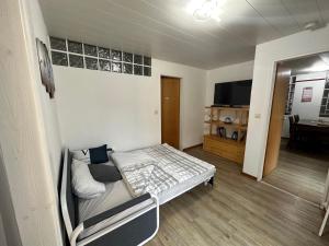 a small room with a bed and a tv at Camping Waldfrieden in Saarburg