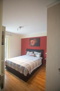 - une chambre dotée d'un lit avec un mur rouge dans l'établissement Athens Riviera Vibes, à Athènes