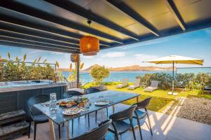 a table on a patio with a view of the water at Çimentepe Residence Deluxe 2 - Villa with Jacuzzi in Yalikavak in Bodrum City