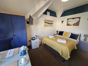 a bedroom with two beds and a tv in it at The Tilstone Guest House in Llandudno