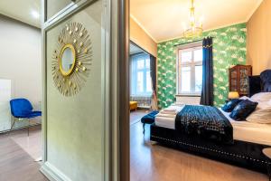 1 dormitorio con cama y espejo en la pared en Apartamenty przy Dworcu, en Przemyśl