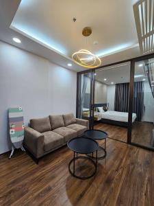 ein Wohnzimmer mit einem Sofa, 2 Tischen und einem Bett in der Unterkunft Serviced apartment with pool- Greenpearl Bắc Ninh in Hòa Ðình