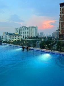 zwei Personen in einem großen Schwimmbad in einer Stadt in der Unterkunft Serviced apartment with pool- Greenpearl Bắc Ninh in Hòa Ðình