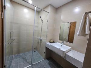 ein Bad mit einem Waschbecken und einer Glasdusche in der Unterkunft Serviced apartment with pool- Greenpearl Bắc Ninh in Hòa Ðình