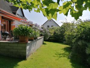 a garden with potted plants on a retaining wall at Pension Haus Anneliese in Ueckeritz
