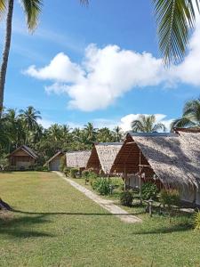 a row of houses with palm trees in the background at koh mook oyoy reggaebar bungalow in Koh Mook