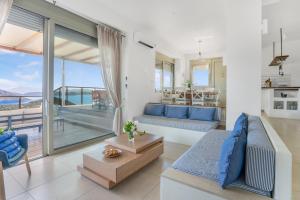 salon z niebieską kanapą i balkonem w obiekcie Alfresco Villas w mieście Sivota