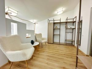 uma sala de estar com duas cadeiras e uma mesa em Higina Spa Hotel em Truskavets