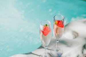 two champagne glasses with a strawberry in them at Forest Corner Luxury Apartment with Hot Tub in North Ballachulish