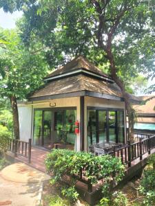 una pequeña casa con un porche y un árbol en สงขลาคีรี รีสอร์ท SongkhlaKeeree Resort, en Ban Khao Rup Chang