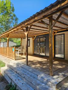 a large wooden deck with a house at Camping La Marmotte in Ax-les-Thermes