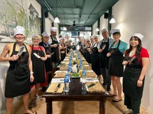 a group of people standing around a table with food at Awesome Hanoi Hostel & Travel in Hanoi